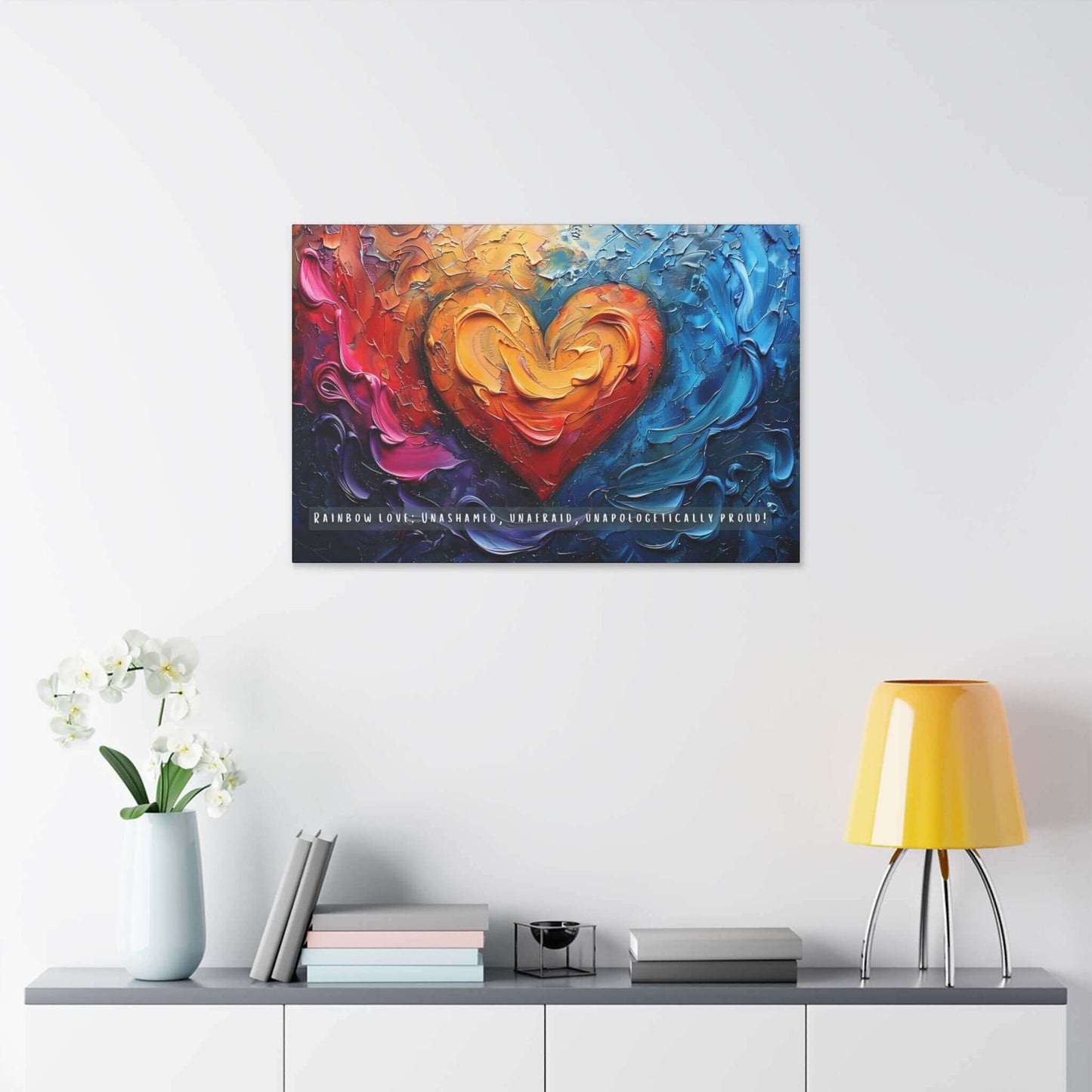 The Rainbow Love: Bold Gay Pride Canvas Wall Art by Printify (PR-6W-004c) features a vividly colorful painting with a heart at the center, surrounded by swirling abstract patterns in shades of red, orange, yellow, blue, and purple. At the bottom, it proudly displays the text: “RAINBOW LOVE: UNASHAMED, UNAFRAID, UNAPOLOGETICALLY PROUD!”—a vibrant celebration of diversity and pride within the LGBTQ+ community.