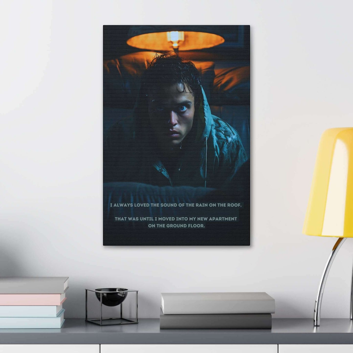 A person with wet hair and a distressed expression is sitting on a couch in a dimly lit room, illuminated by the soft glow of a lamp behind them. Text at the bottom of the image reads: "I always loved the sound of the rain on the roof. That was until I moved into my new apartment on the ground floor." This eerie snapshot captures the essence of Printify's "Dreadful Drizzle: Atmospheric Fear Canvas Wall Art with Shocking 2-Sentence Horror Story.