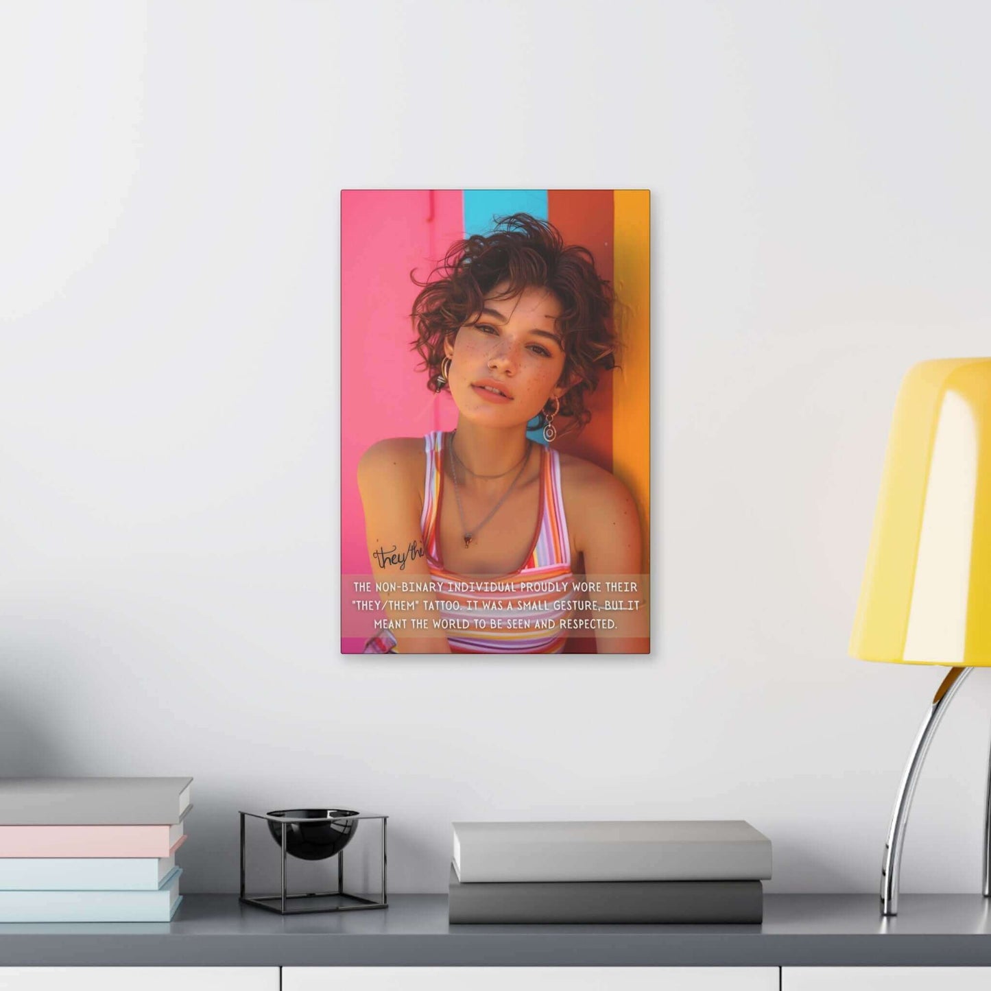 A young person with curly hair, wearing a striped tank top and earrings, stands against a vibrant, colorful wall adorned with the "They/Them: Bold Gay Pride Canvas Wall Art" by Printify. A text overlay reads, "The non-binary individual proudly wore their 'they/them' tattoo. It was a small gesture of self-expression, but it meant the world to be seen and respected.