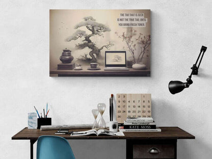 A workspace includes a laptop, a cup, a teapot, a stack of books, and a plant. An Asian-Inspired Poster Wall Art with Bonsai & Clever Haiku by Printify blends seamlessly with the real objects. The humorous Asian-themed text reads, "The Tao that is seen is not the true Tao, until you bring fresh toner.